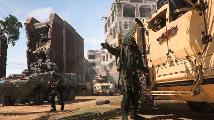 Screenshot showing Modern Warfare 2 players standing next to vehicles in a desert city
